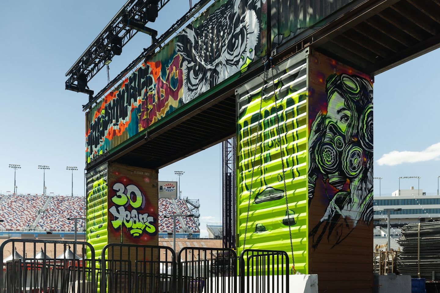 A container gate painted with a "30 Years" piece, neon green drips and a figure in a gas mask