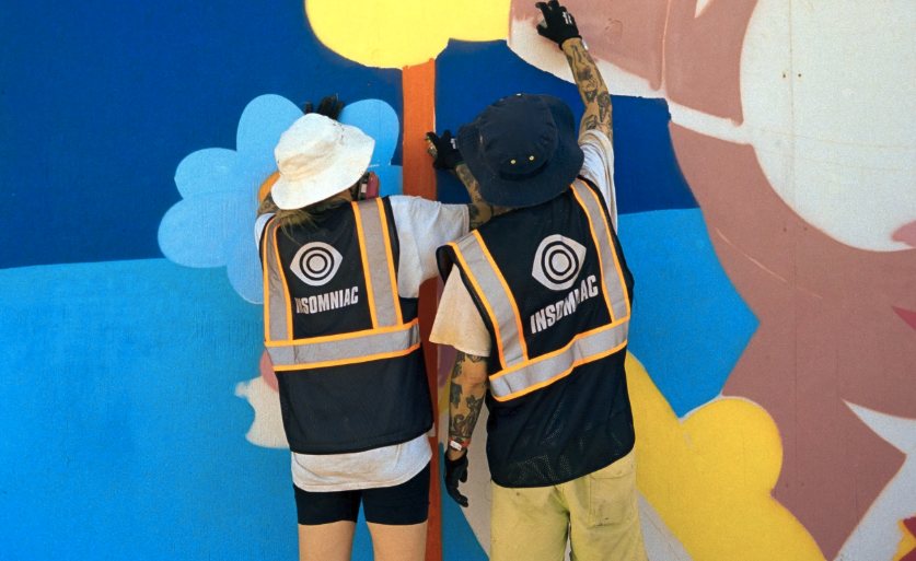 DabsMyla painting a mural in Insomniac vests